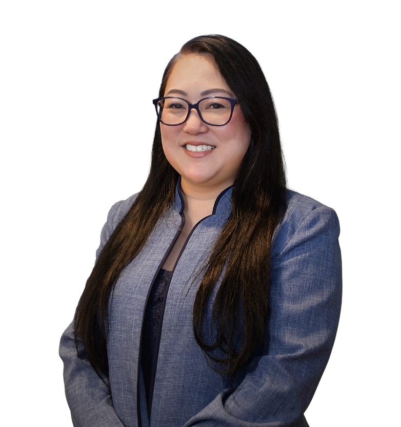 Ami Kim stands smiling in a grey suit