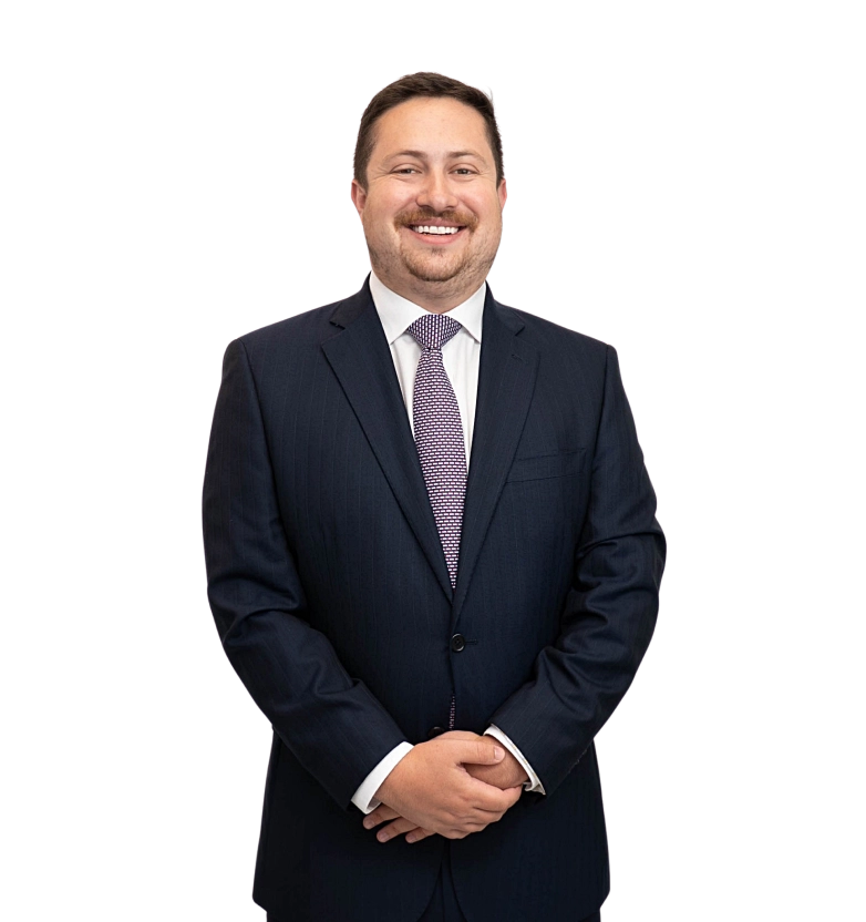 Luke Kuba stands smiling in a suit