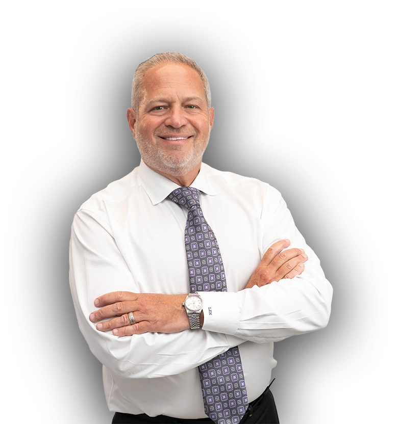 Lance Kuba stands smiling in a white button-up shirt and a geometric tie